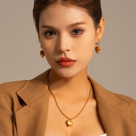 Model Wearing Vintage gold heart-shaped hoop earrings – 18K gold-plated, waterproof, hypoallergenic by STUD (Shop Till You Drop)