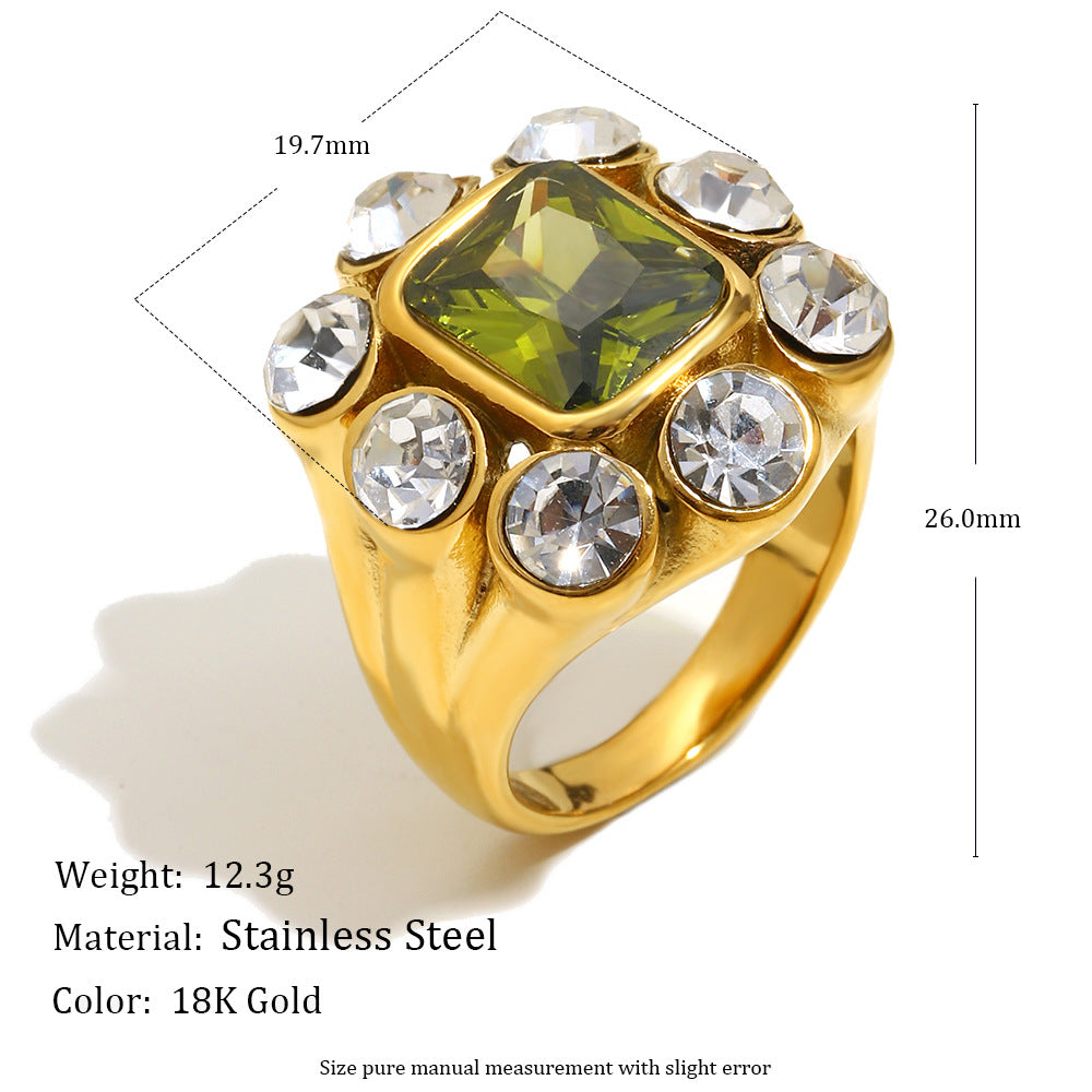 Close-up of 18K gold-plated stainless steel statement ring with green gemstone and white zircon crystals