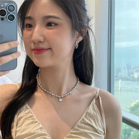 Model Wearing Silver pearl and diamond necklace – electroplated geometric design by STUD-Shop Till You Drop