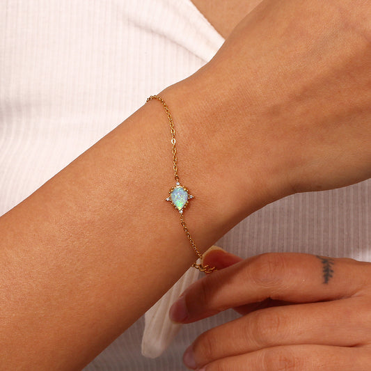 Model Wearing Gold bracelet with blue waterdrop opal charm – vintage design, hypoallergenic by STUD (Shop Till You Drop)