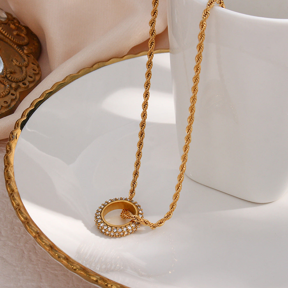 Twisted gold rope chain necklace with zircon circle pendant on display