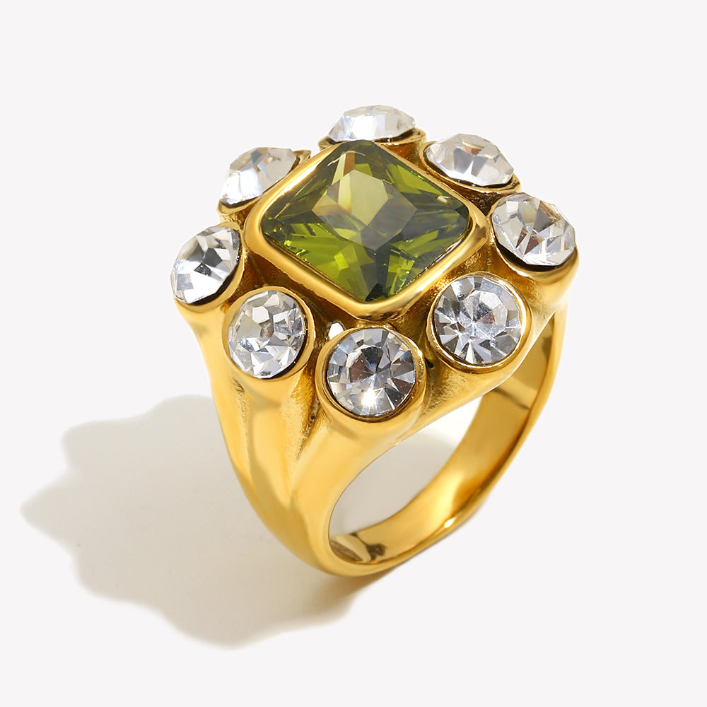 Close-up of 18K gold-plated stainless steel statement ring with green gemstone and white zircon crystals