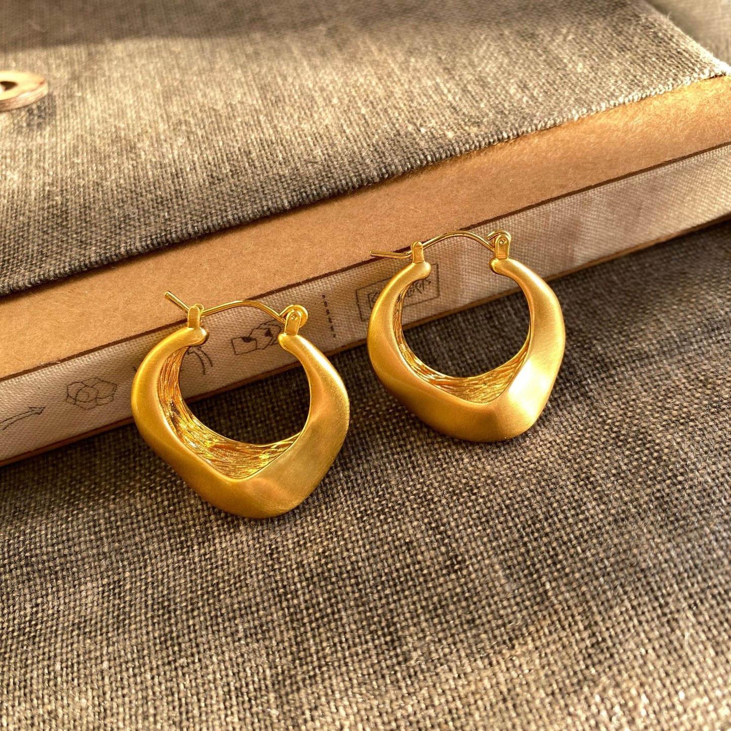 Matte gold handcrafted hoop earrings with irregular modern design by STUD