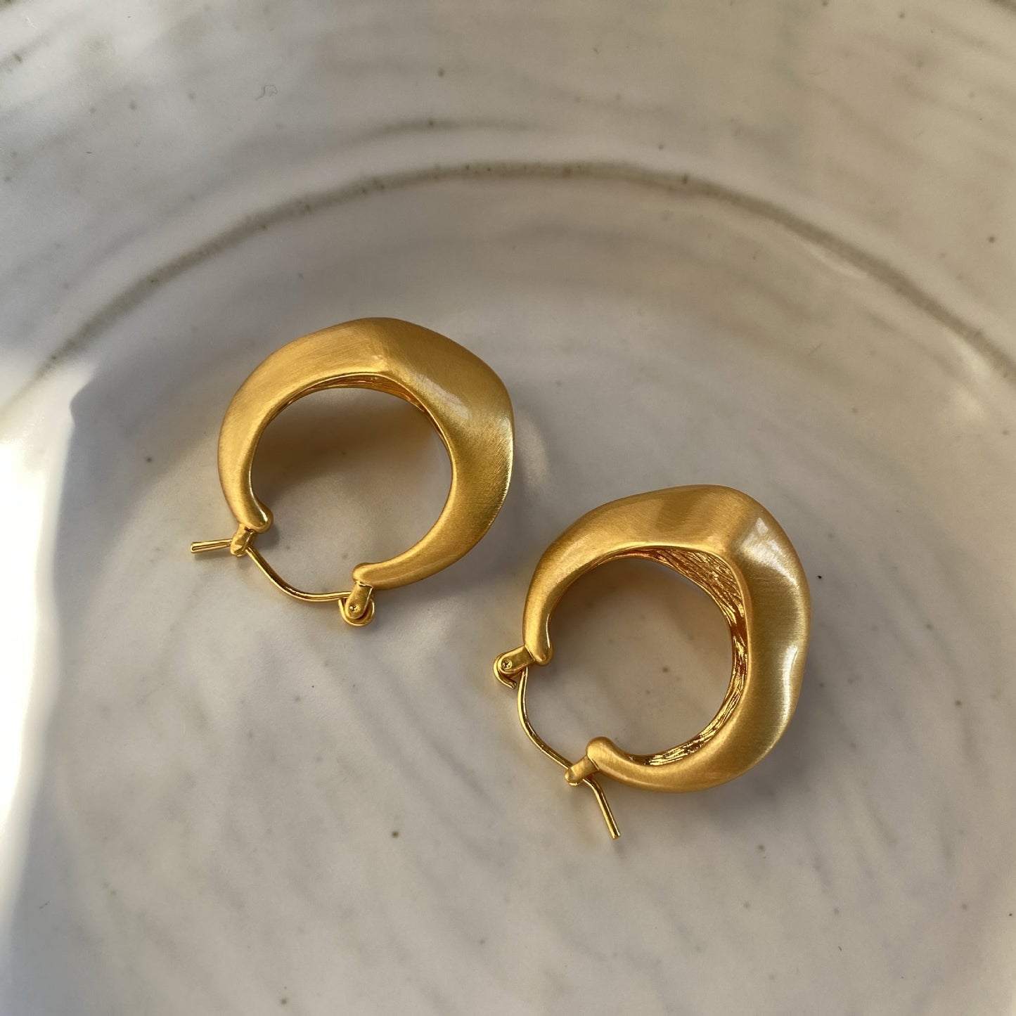 Matte gold handcrafted hoop earrings with irregular modern design by STUD