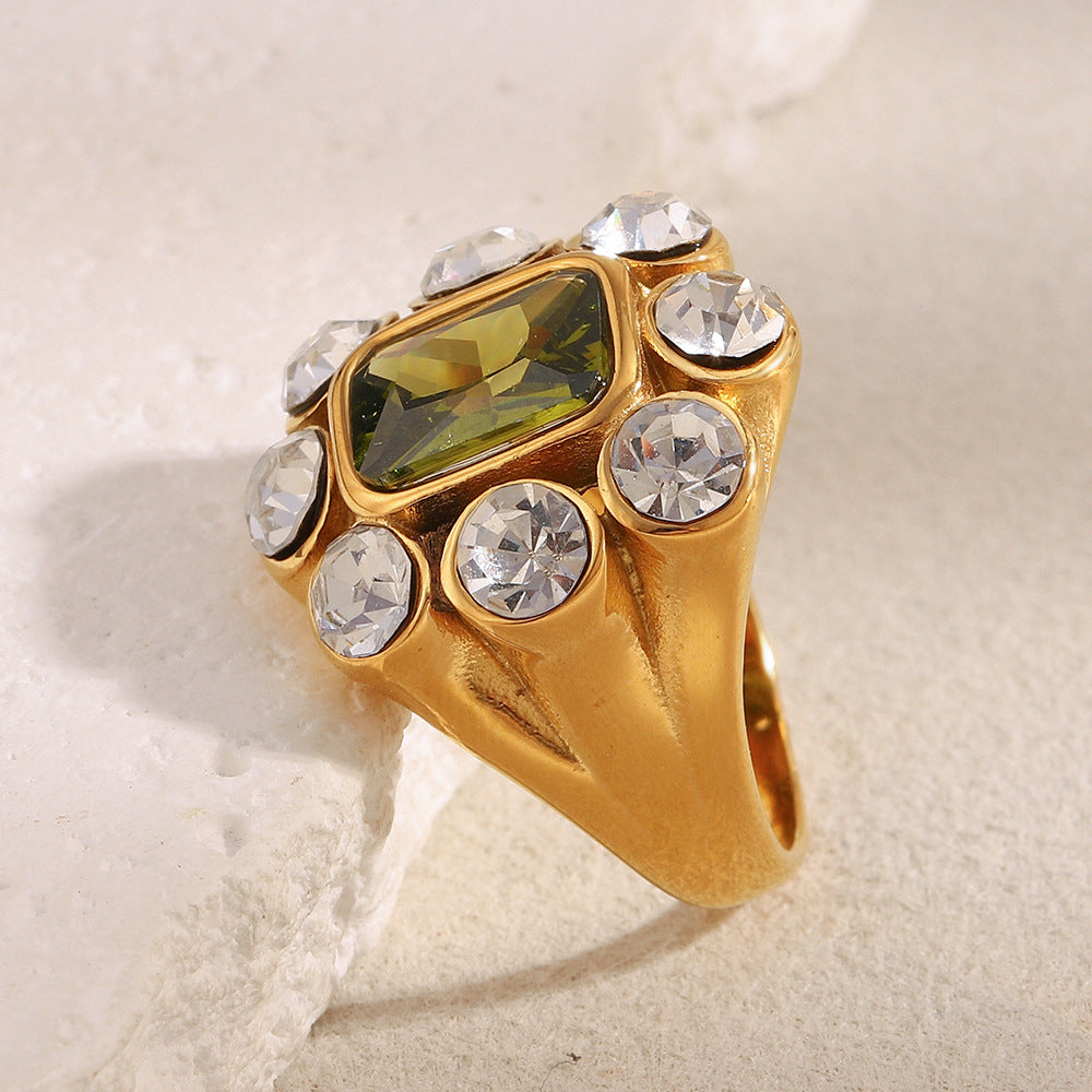 Close-up of 18K gold-plated stainless steel statement ring with green gemstone and white zircon crystals