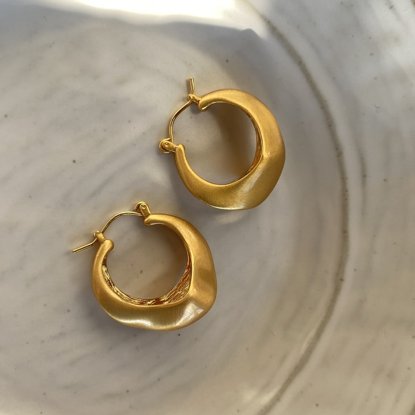 Matte gold handcrafted hoop earrings with irregular modern design by STUD