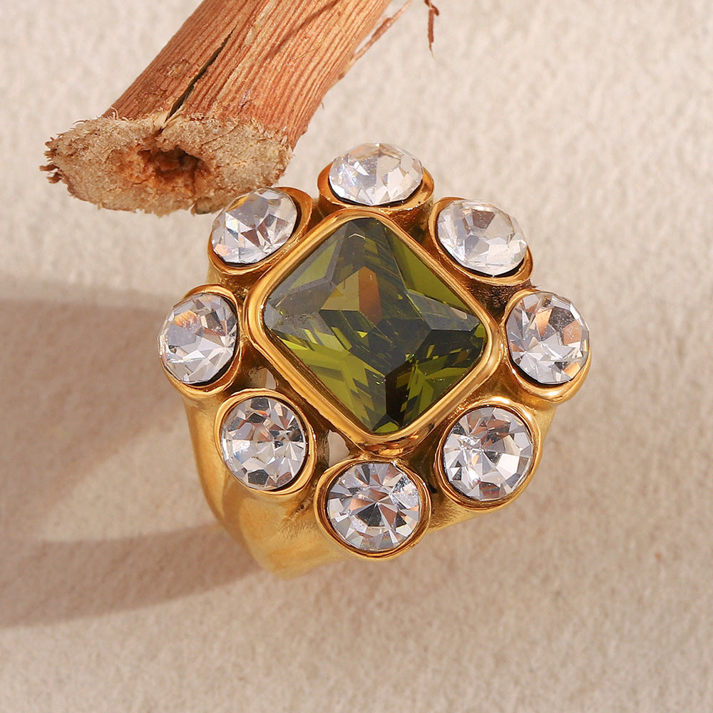 Close-up of 18K gold-plated stainless steel statement ring with green gemstone and white zircon crystals