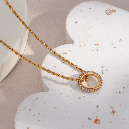 Twisted gold rope chain necklace with zircon circle pendant on display
