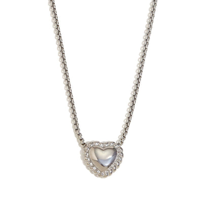 Close-up of twisted silver heart pendant necklace