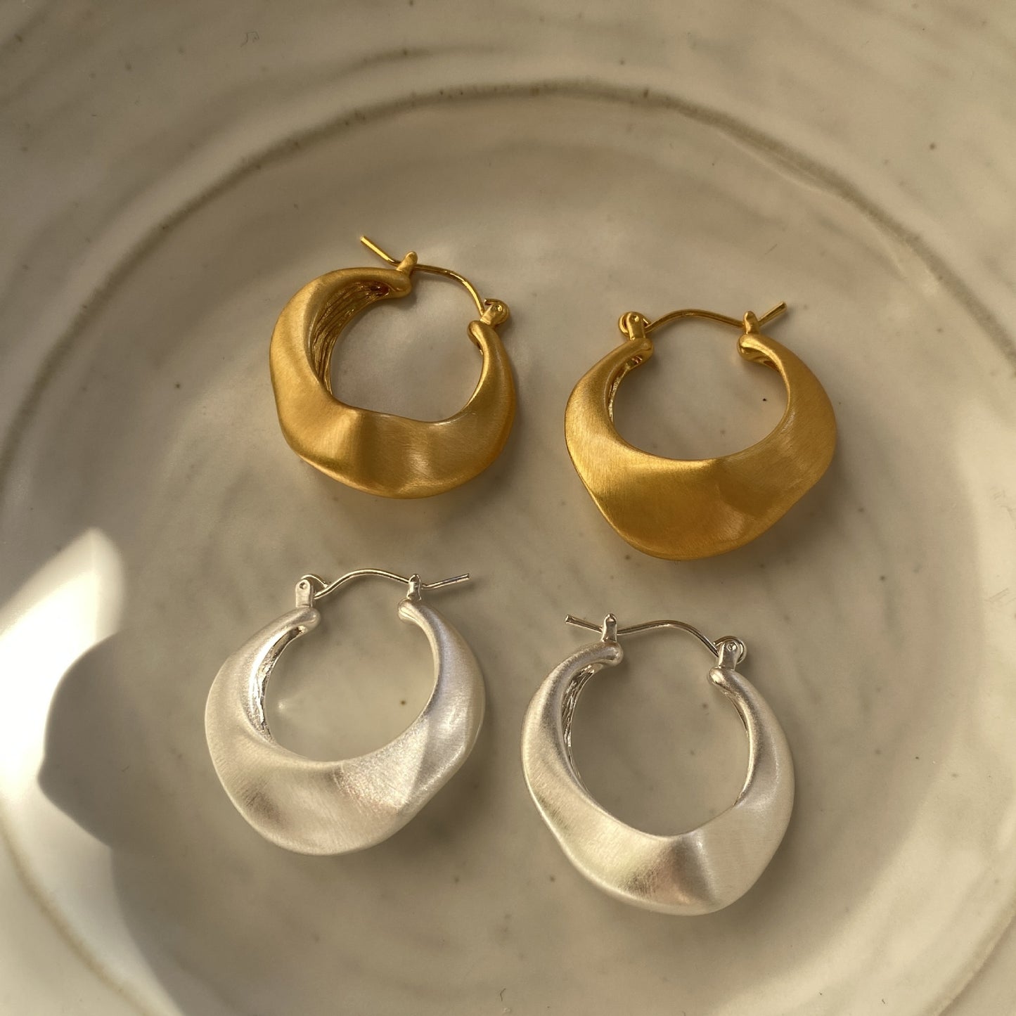Matte gold handcrafted hoop earrings with irregular modern design by STUD