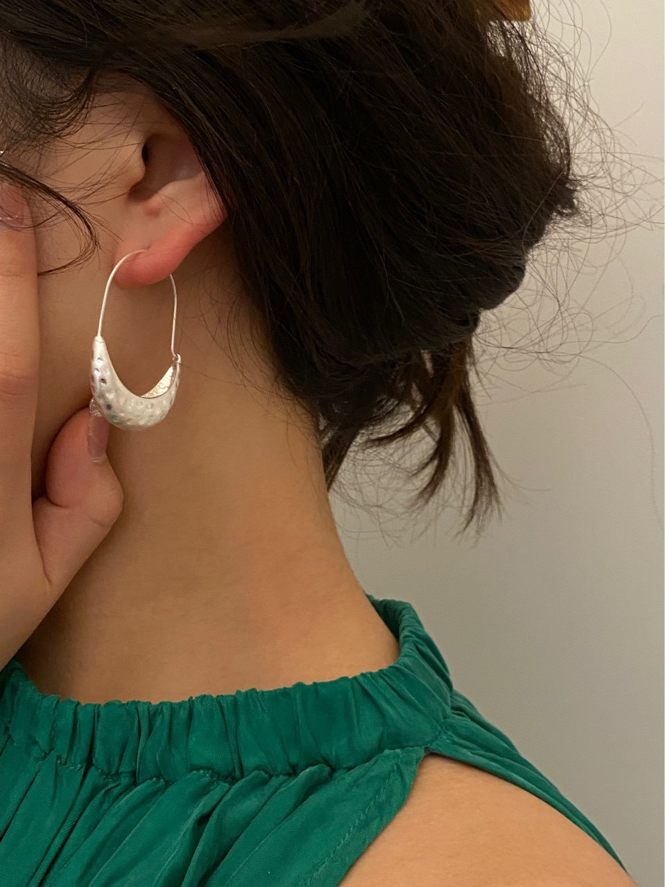 Close-up of sculptural crescent hoop earrings