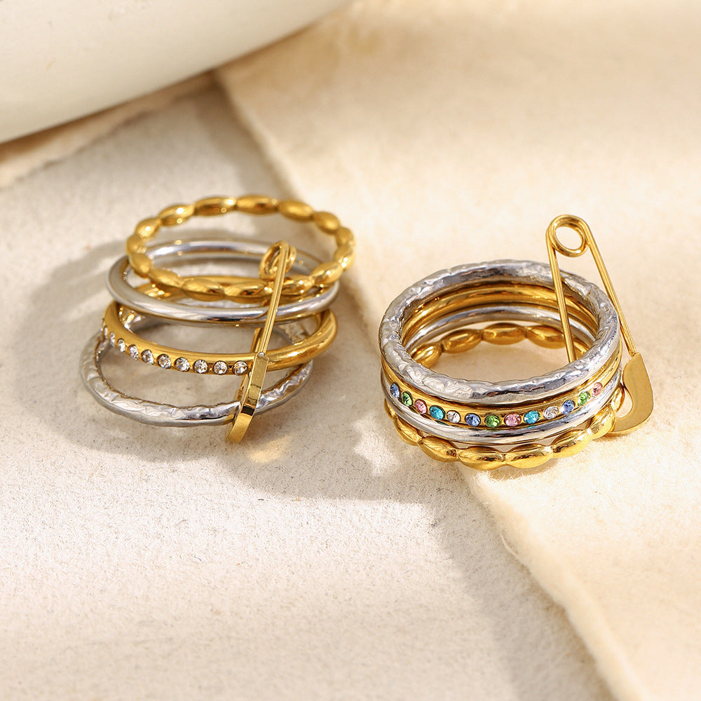 Stacked 18K gold and silver ring with zircon stones and safety pin design