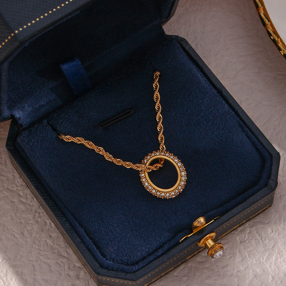 Twisted gold rope chain necklace with zircon circle pendant on display