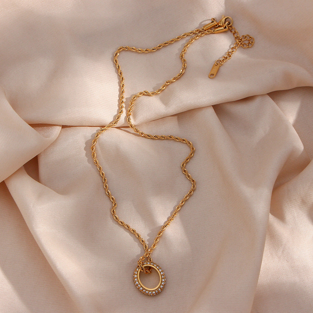 Twisted gold rope chain necklace with zircon circle pendant on display