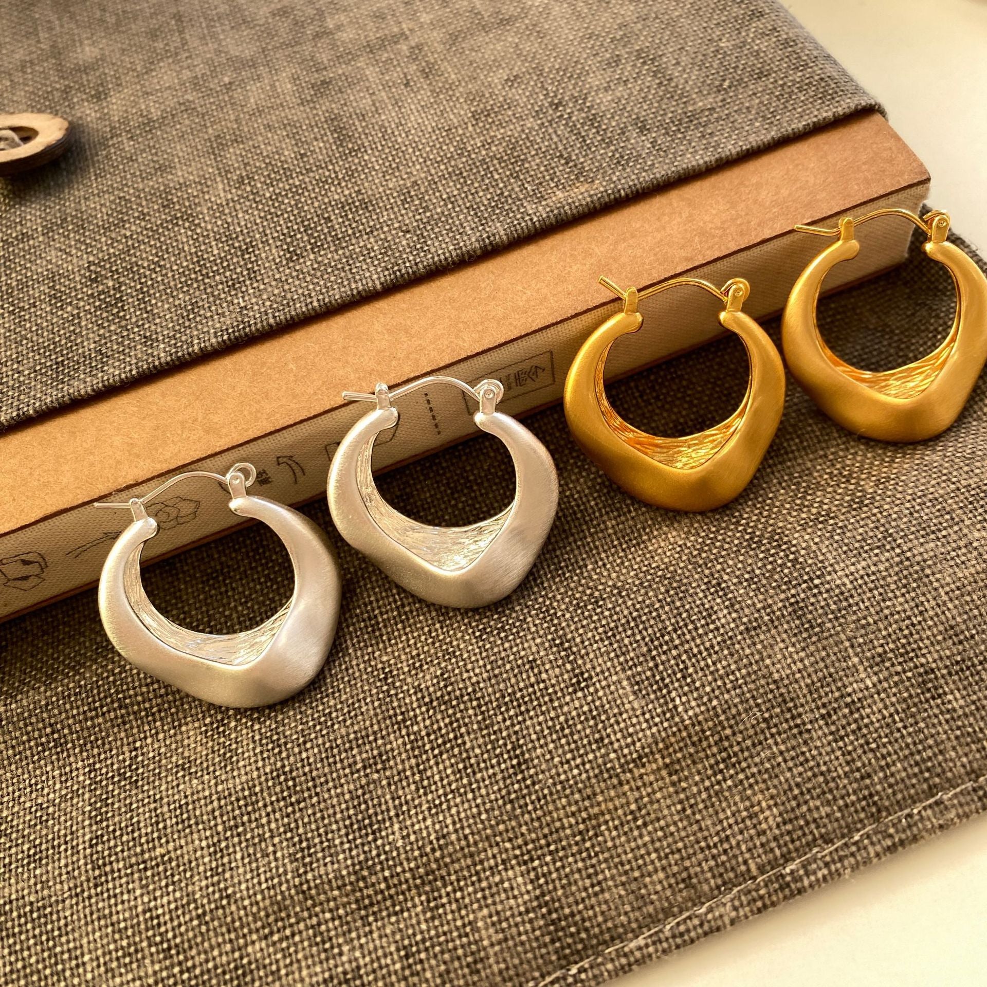 Matte gold handcrafted hoop earrings with irregular modern design by STUD
