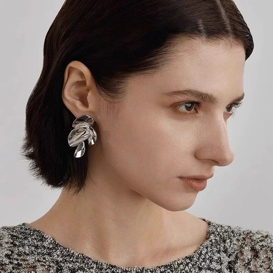 Glossy twisted leaf design silver stud earrings with sculptural detailing