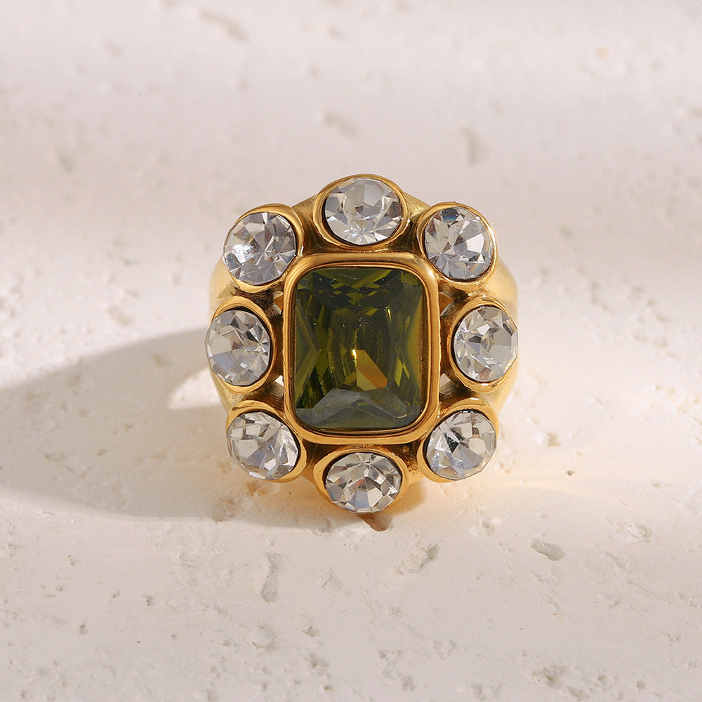 Close-up of 18K gold-plated stainless steel statement ring with green gemstone and white zircon crystals