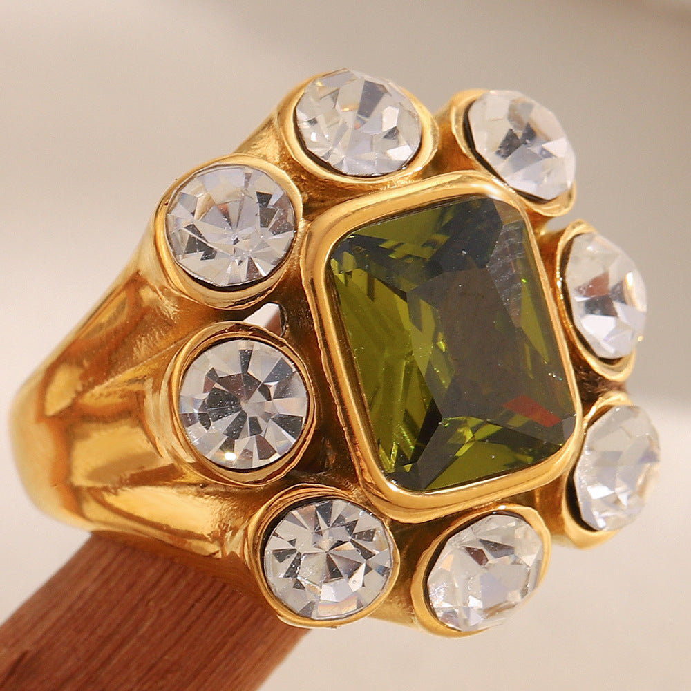 Close-up of 18K gold-plated stainless steel statement ring with green gemstone and white zircon crystals