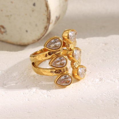 Bold 18K gold-plated open ring with double teardrop zircon stones on hammered stainless steel band – French statement design