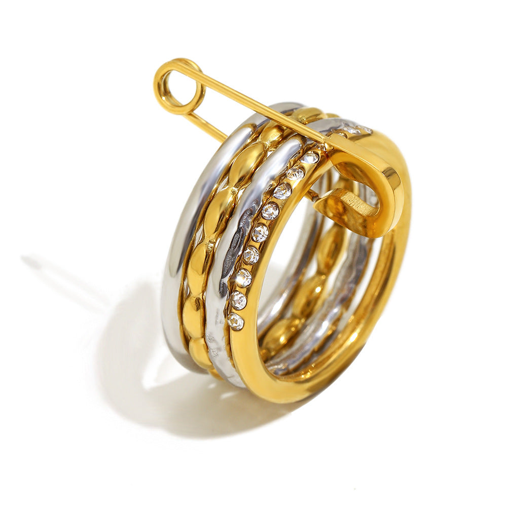 Stacked 18K gold and silver ring with zircon stones and safety pin design
