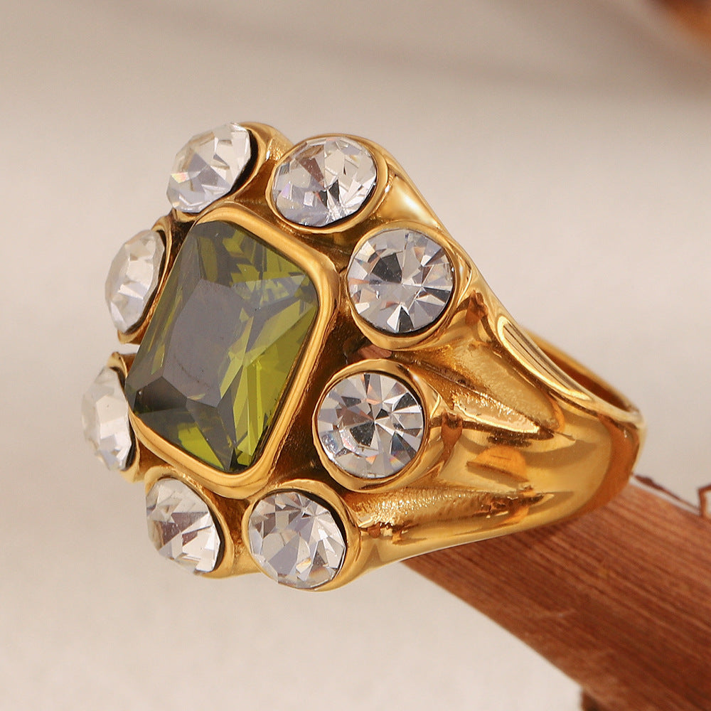 Close-up of 18K gold-plated stainless steel statement ring with green gemstone and white zircon crystals
