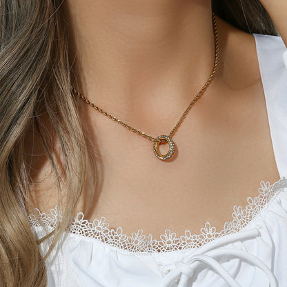 Twisted gold rope chain necklace with zircon circle pendant on display