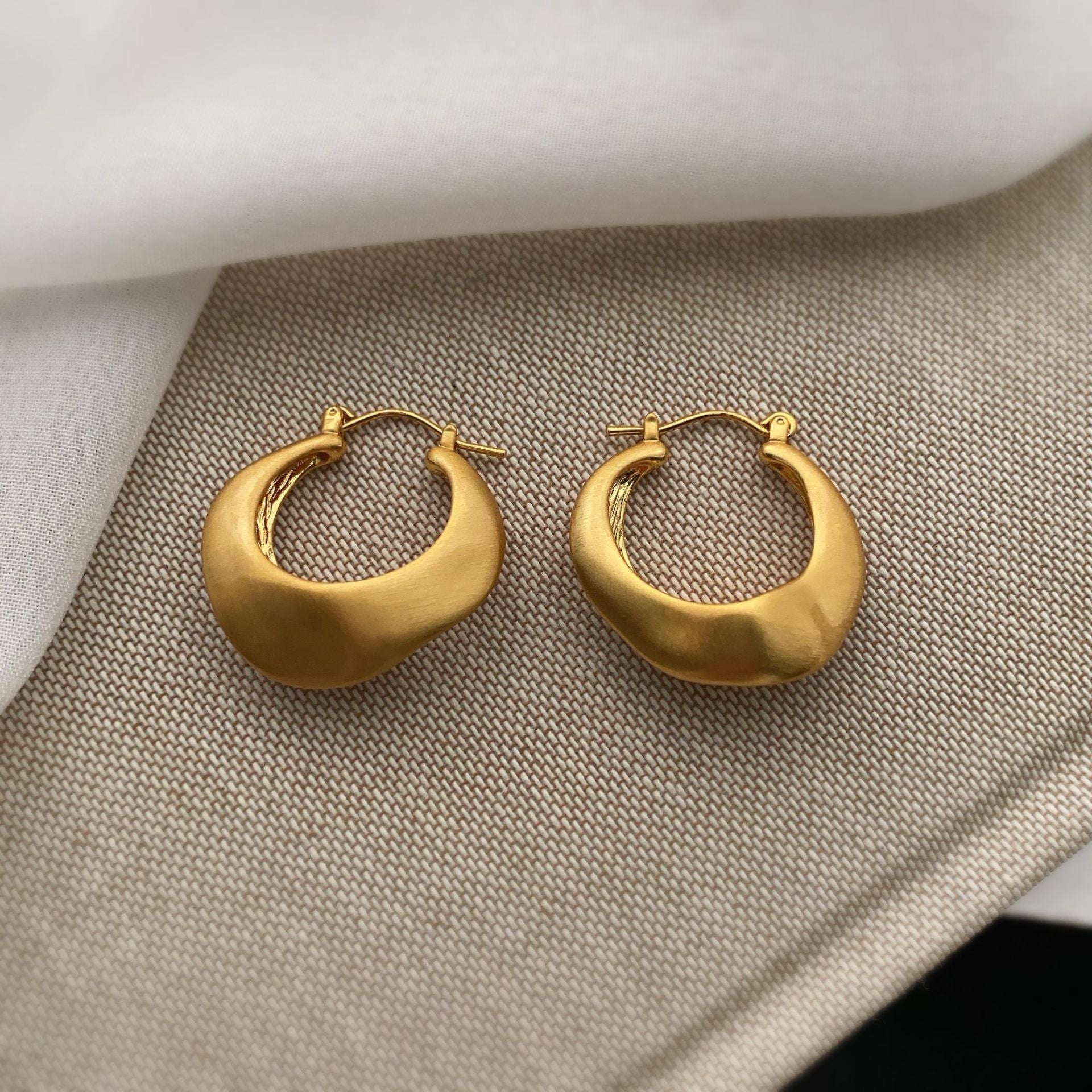 Matte gold handcrafted hoop earrings with irregular modern design by STUD