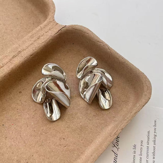 Glossy twisted leaf design silver stud earrings with sculptural detailing