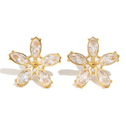 Gold flower-shaped earrings with clear gemstones on a white background