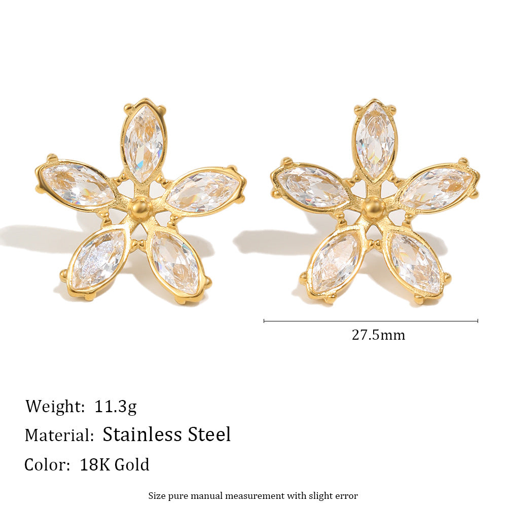 Gold flower-shaped earrings with clear stones on a white background, showing weight, material, and color information.